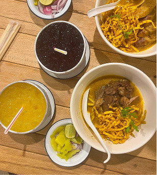 Khao soi y otros platos tailandeses sobre una mesa de madera